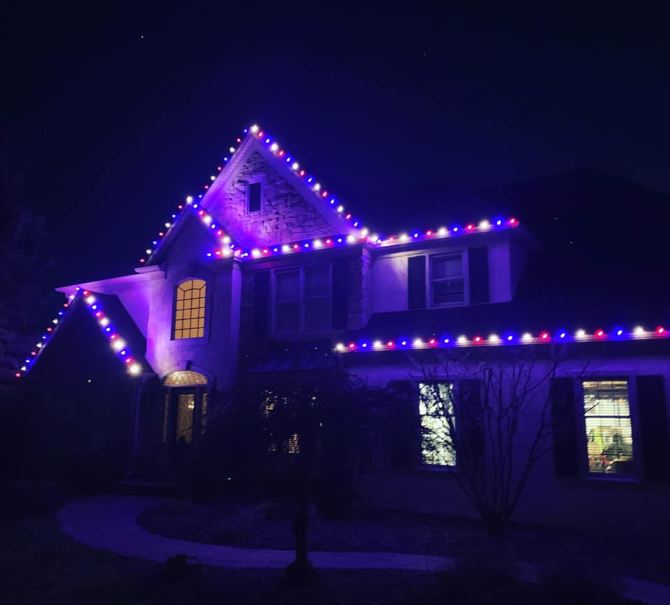 large house with lights strung around it, purple glow