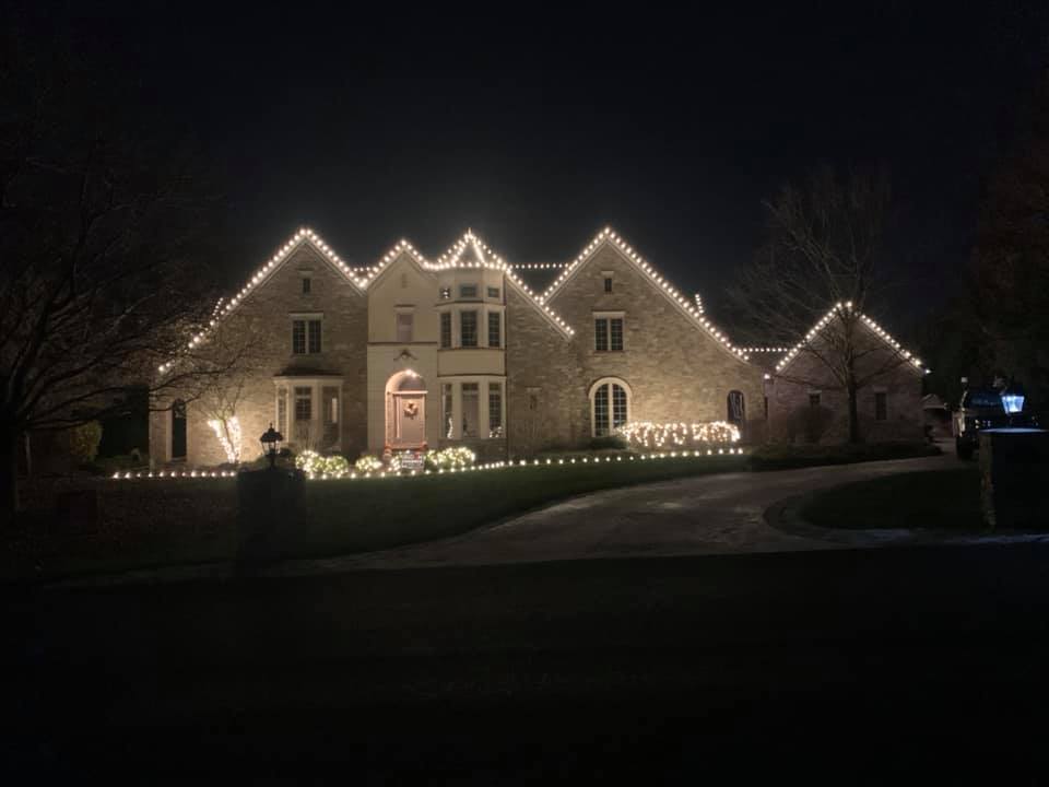 large house with lights strung around it and the landscape